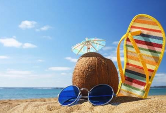 Dezembro laranja. Coco, chinelo e óculos de sol na praia.