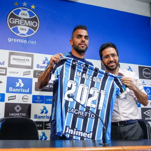 O jogador recebeu das mãos do dirigente gremista uma camisa com o número 2021 alusiva a data do novo contrato. Foto: Lucas Uebel/Divulgação