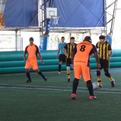 Quadra do Ginásio De La Costa, ênfase dois jogadores Acergs de camisa e short laranja durante o jogo contra o Penãrol. Foto: Assessoria Acergs/Divulgação