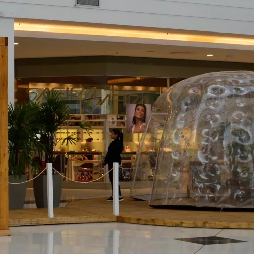 Espaço dentro de um shopping com um domo transparente.