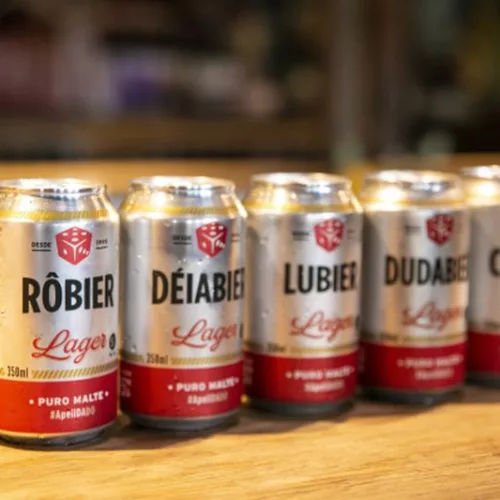 Latas de cerveja Dado Bier com apelidos seguidos de Bier. São cervejas Lager, 350ml, puro malte. Rôbier, Déiabier, Lubier, Dudabier, Celobier.