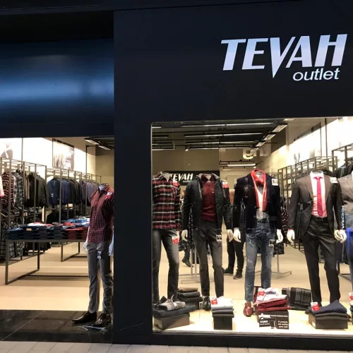 Vitrine de loja masculina com ternos e roupas casuais em manequins com o nome Tevah Outlet.