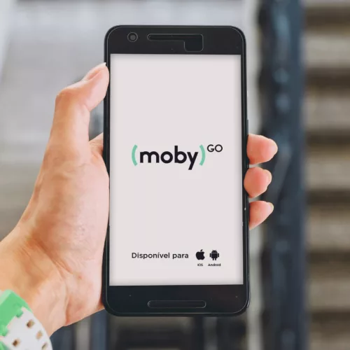 Uma mão segura um celular com o nome do plicativo Moby Go e s plataformas Android e iOS.