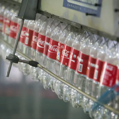 Garrafas vazias de Coca-Cola em linha de produção.