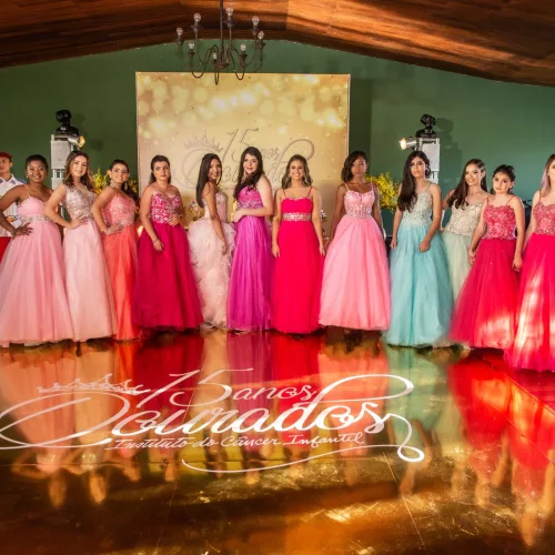 Festa de debutantes: meninas em seus vestidos de festa, de diferentes cores, com o nome do evento no chão