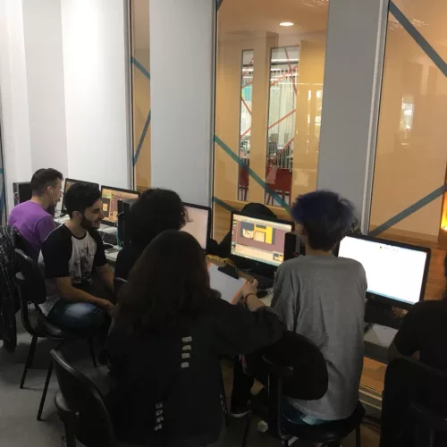 Jogos Digitais. Alunos trabalham sentados em frente a computadores.
