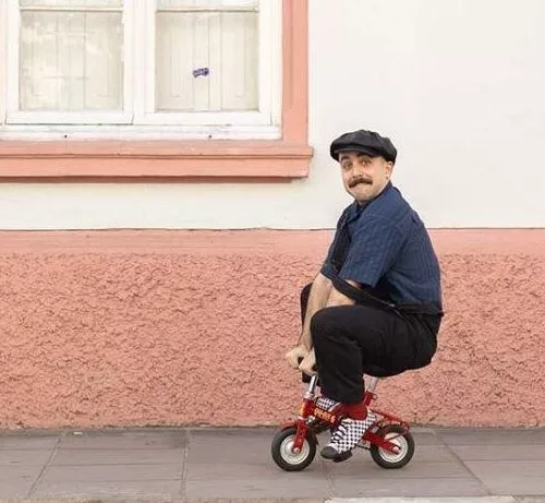 Um homem em um triciclo em dimensões muito pequenas.