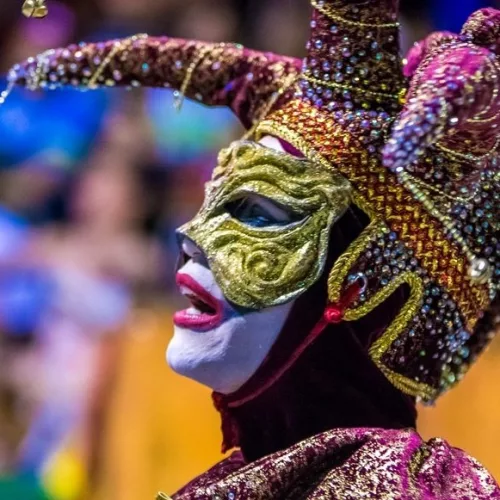 Pessoa com máscara e fantasia. Carnaval Fora de Época de Uruguaiana.