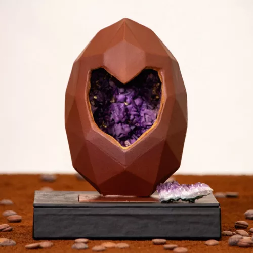 Caminho do Coelhinho. Ovo de chocolate com um buraco em forma de coração e simulando dentro uma pedra ametista.