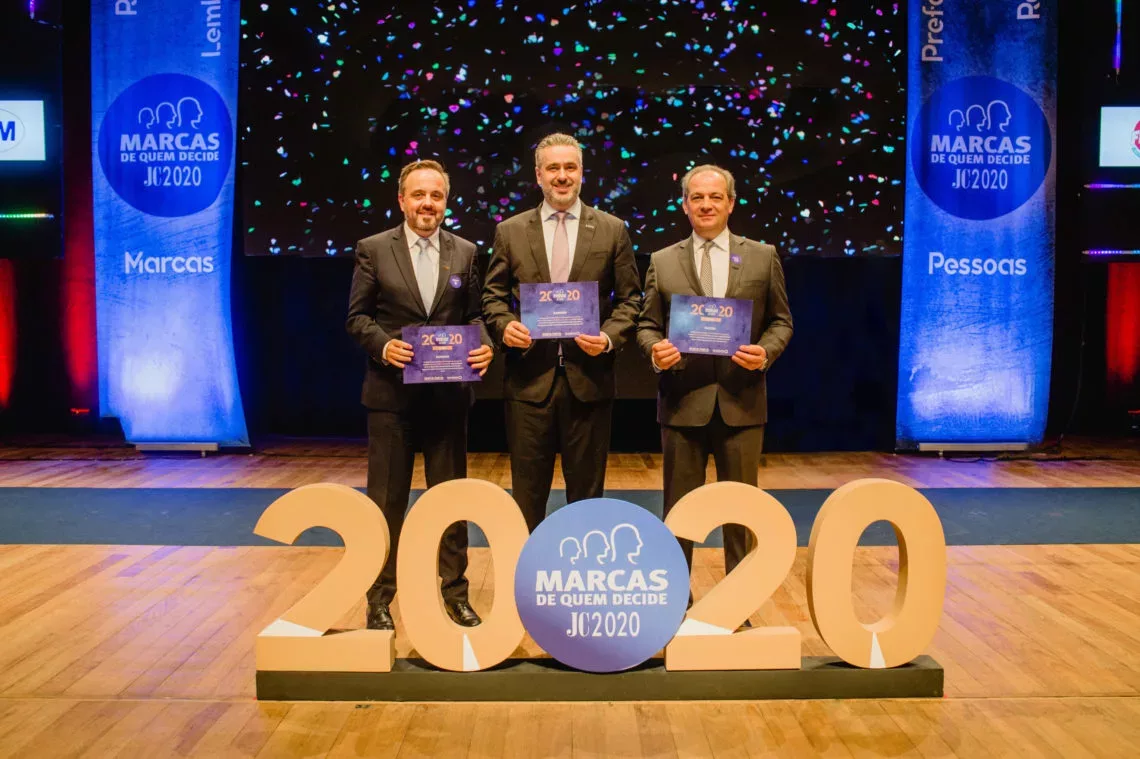 Empresas Randon. Três homens carregam um certificado em um palco e à sua frente o ano 2020 e o nome do evento.