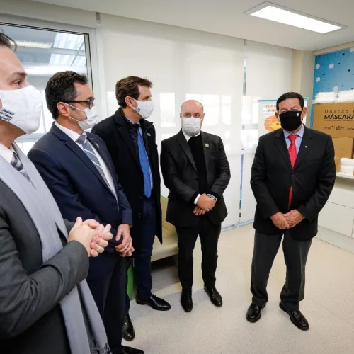 CMPC e doação de máscaras. Cinco homens usam máscaras e estão próximos de caixas de máscaras.