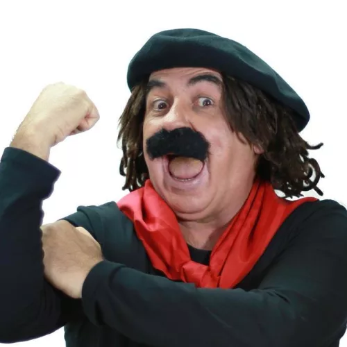 POA Drive-in Show recebe o humorista Jair Kobe com seu personagem gaudério Guri de Uruguaiana. Homem com bigode grande e falso, boina e lenço vermelho faz sinal de "banana" com braço.