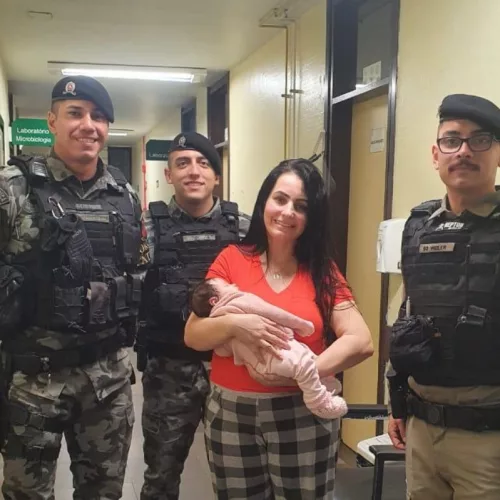 Policiais militares e mãe da bebê posam para foto após salvamento em Cachoeirinha. Foto: Brigada Militar / Divulgação