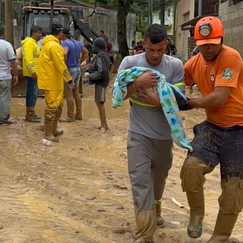 Resgate de homem e bebê em rua coberta de lama em São Sebastião. Foto: Prefeitura de São Sebastião / Divulgação